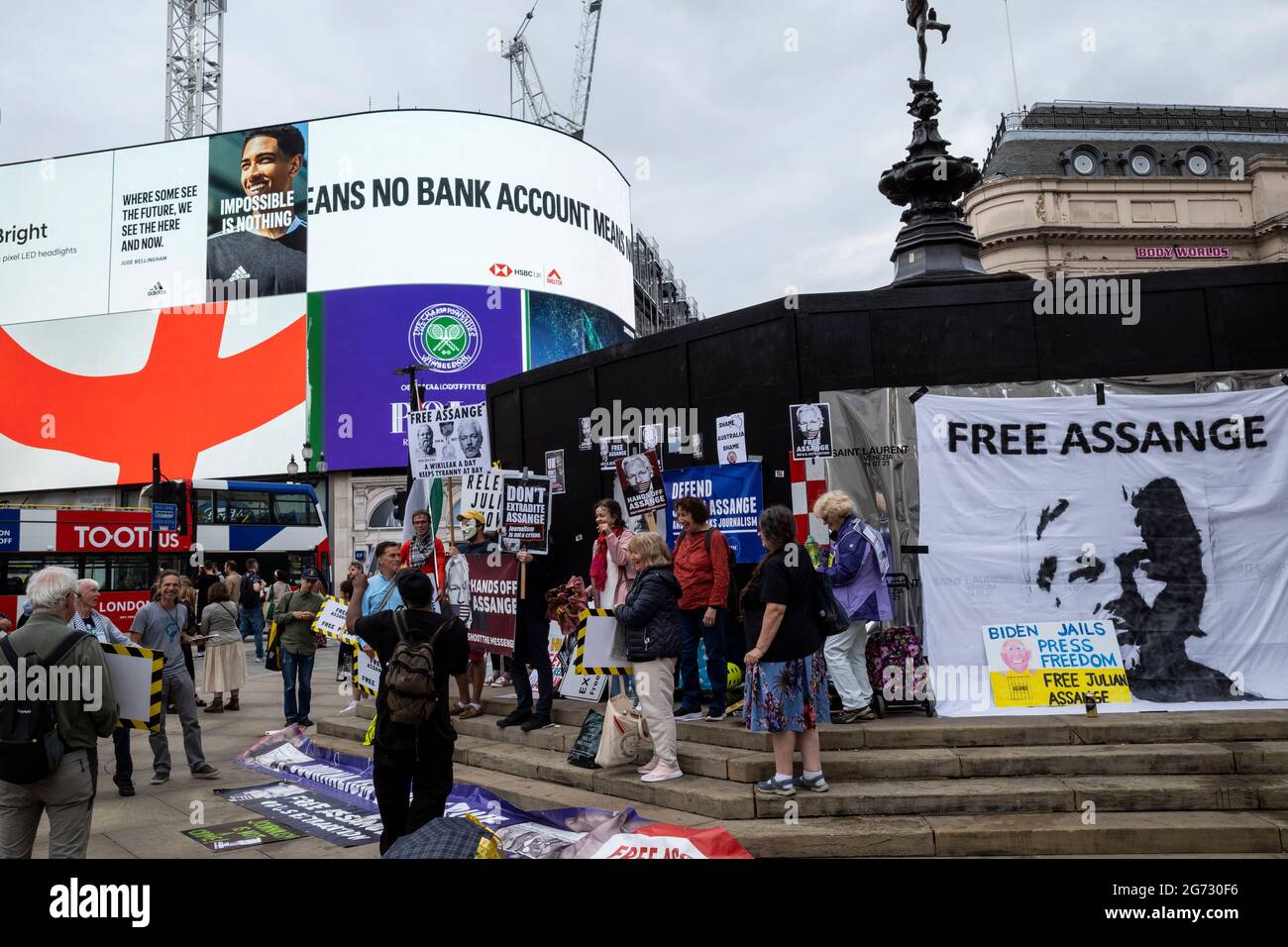 London, UK.  10 July 2021.  Supporters of Julian Assange in Piccadilly Circus at a protest demanding his release.   Wikileaks founder Assange is currently held in Belmarsh prison.  The statue of Eros is currently boarded up ahead of the final of Euro 2020 between Italy and England tomorrow night Wembley Stadium.  Credit: Stephen Chung / Alamy Live News Stock Photo