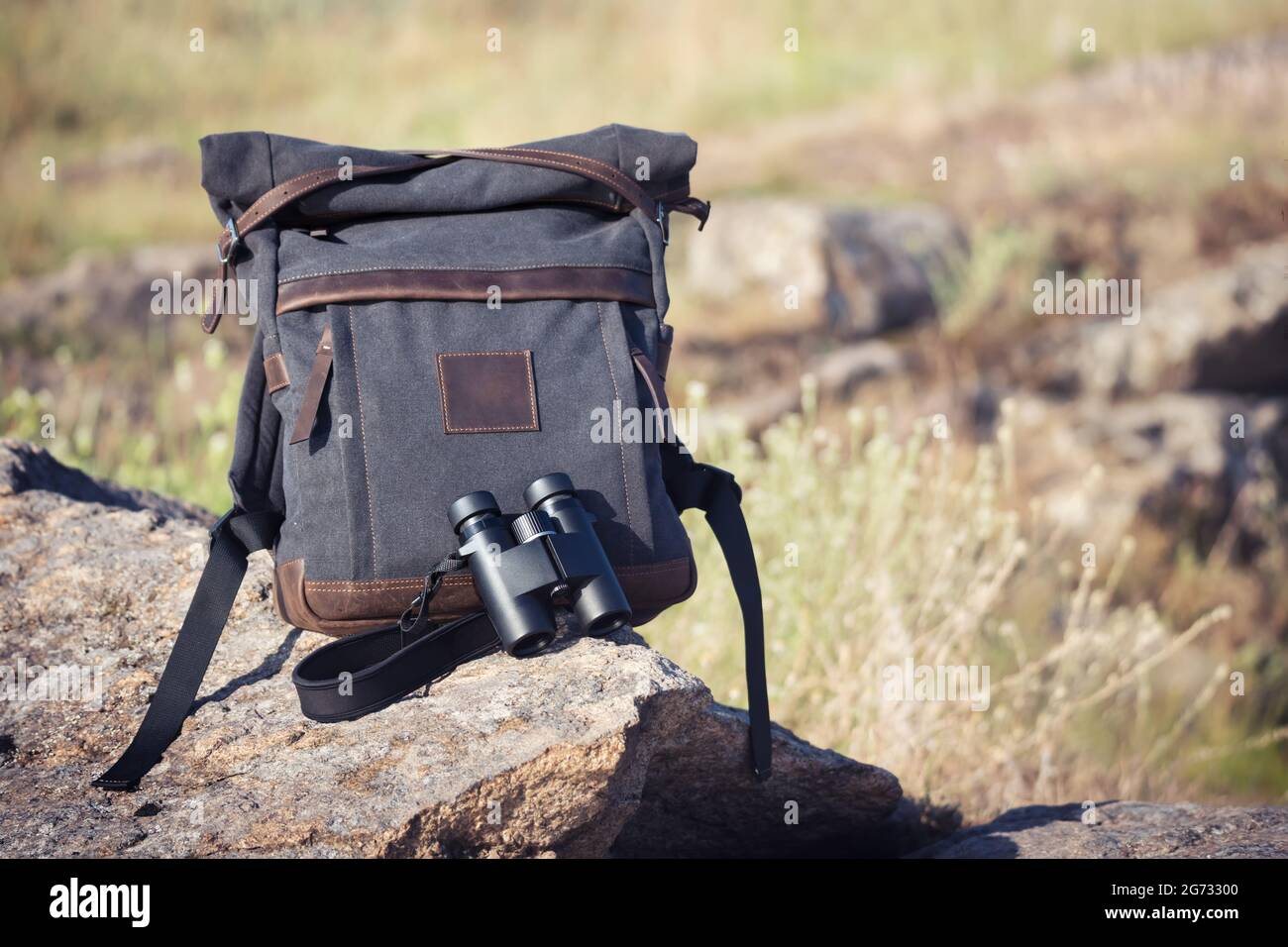 The set for birdwatcher with dark gray backpack and binoculars for looking around and watching
