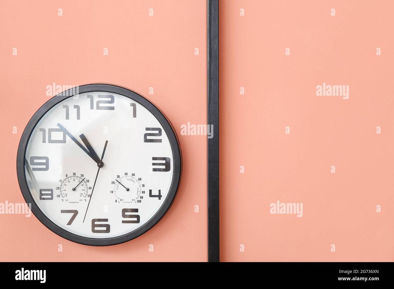 Stylish clock hanging on color wall Stock Photo Alamy