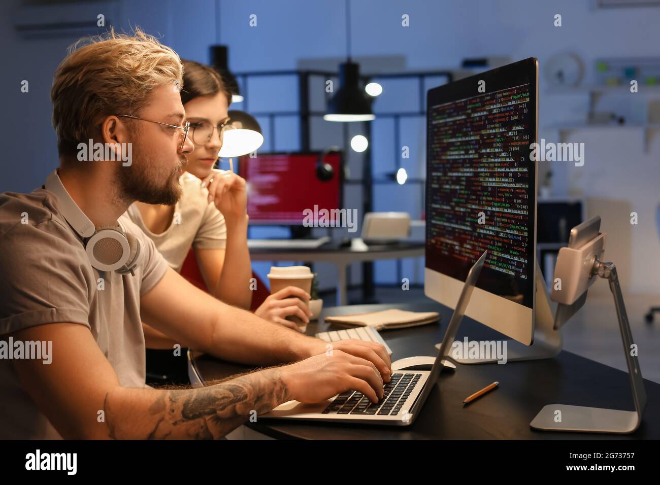 Young programmers working with computer in office at night Stock Photo