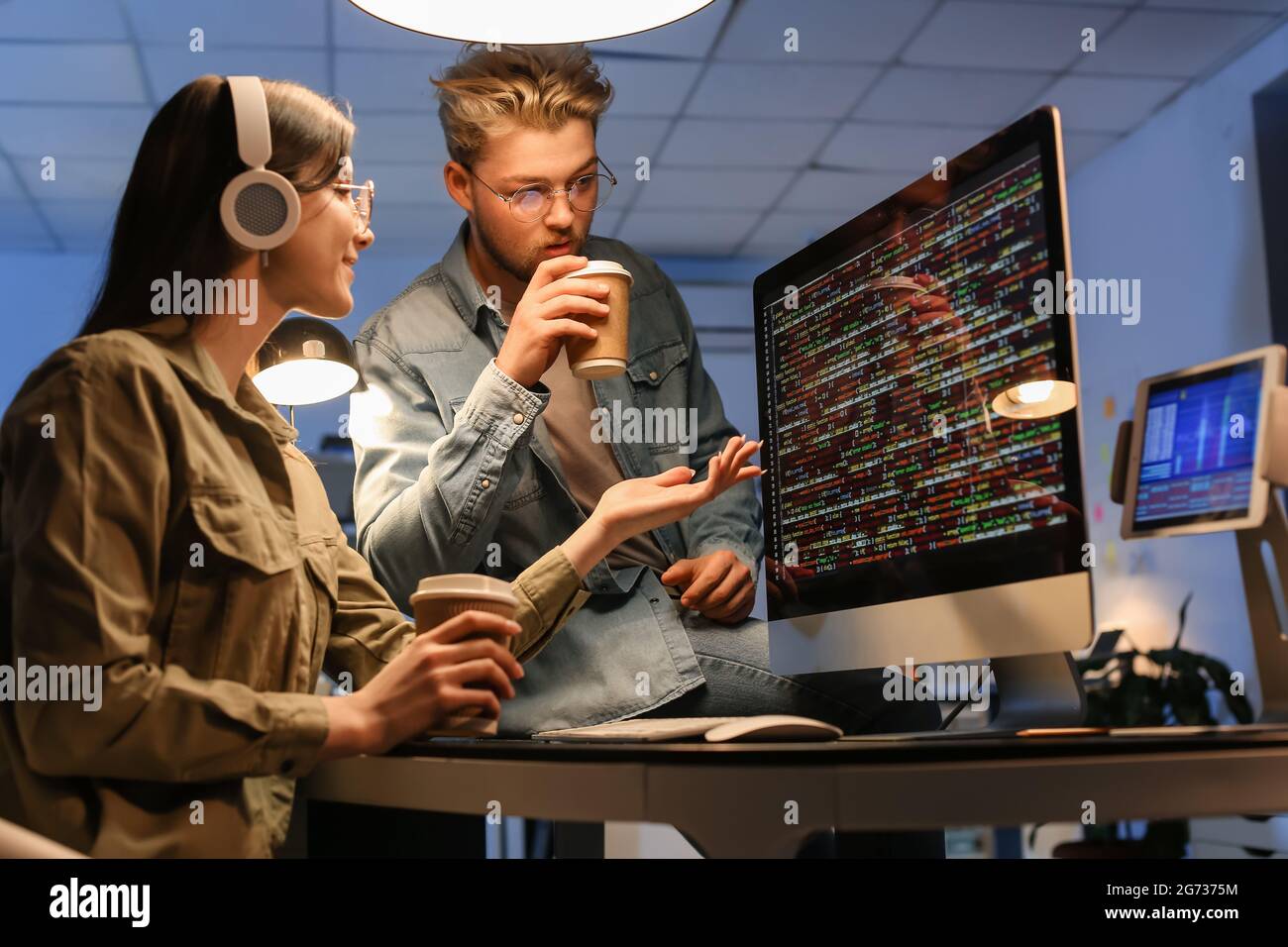 Young programmers working in office at night Stock Photo