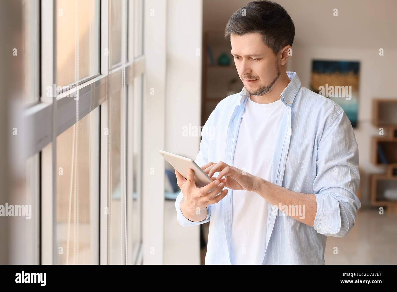 Handsome man using tablet computer at home Stock Photo
