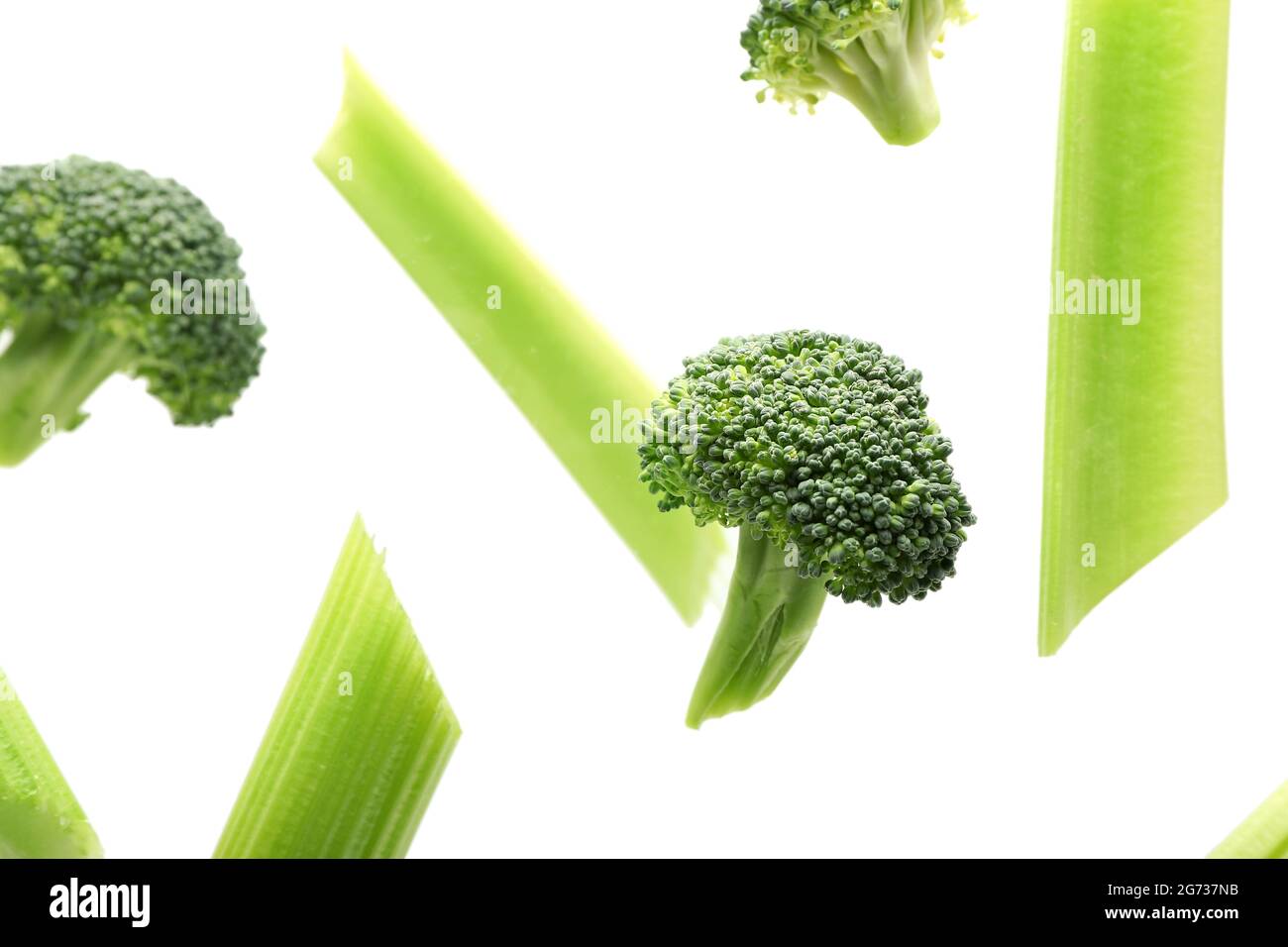 Flying celery and broccoli on white background Stock Photo - Alamy