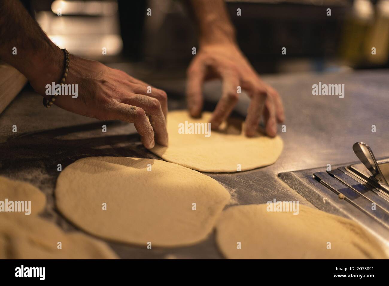 the cook rolls out the dough. Table in flour Stock Photo Alamy