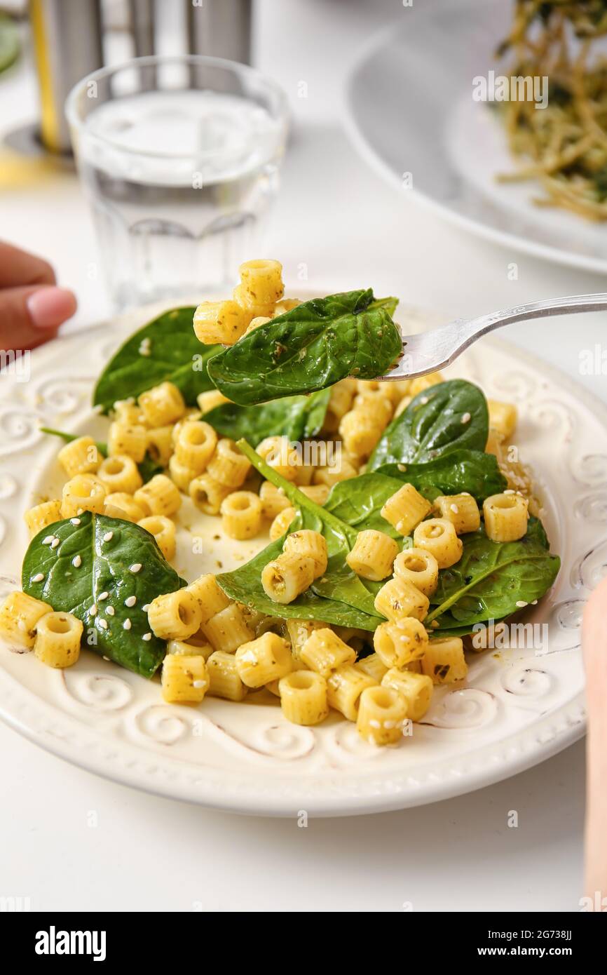 Eating of healthy pasta with spinach at table Stock Photo Alamy