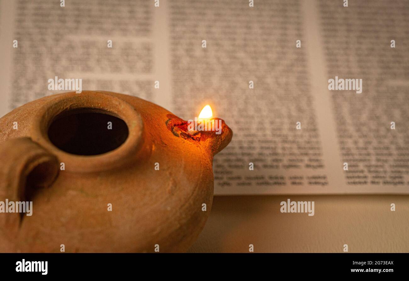 An Ancient Lamp Illuminating the Hebrew Text of the Torah Stock Photo