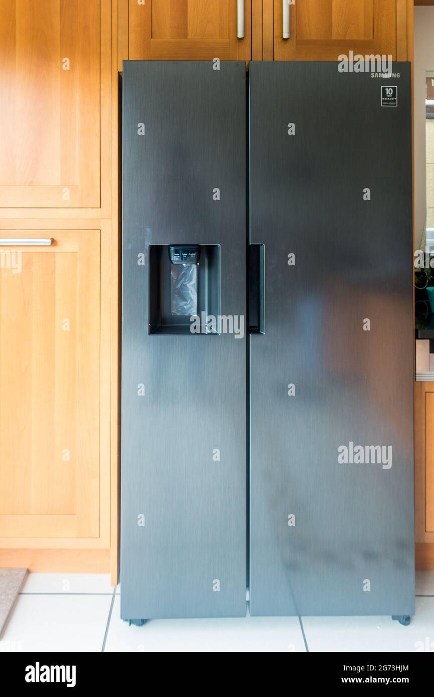 American double door refrigirator fitted within a wooden kitchen cabinet Stock Photo