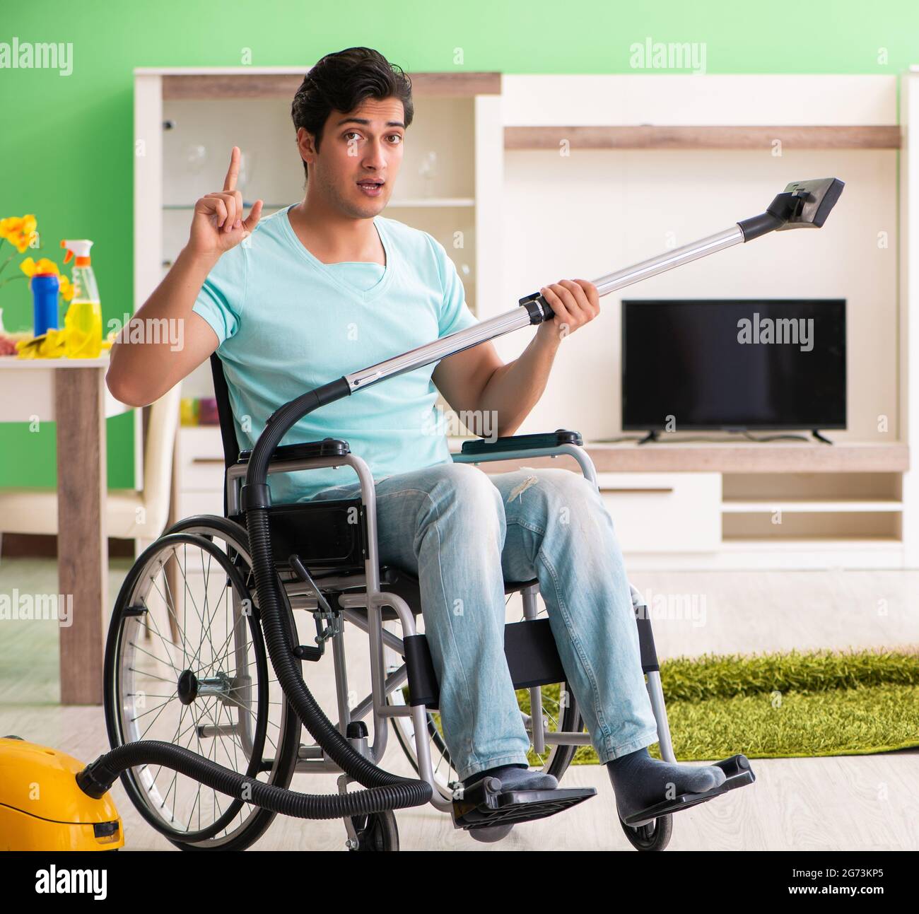 The disabled man on wheelchair vacuum cleaning house Stock Photo Alamy