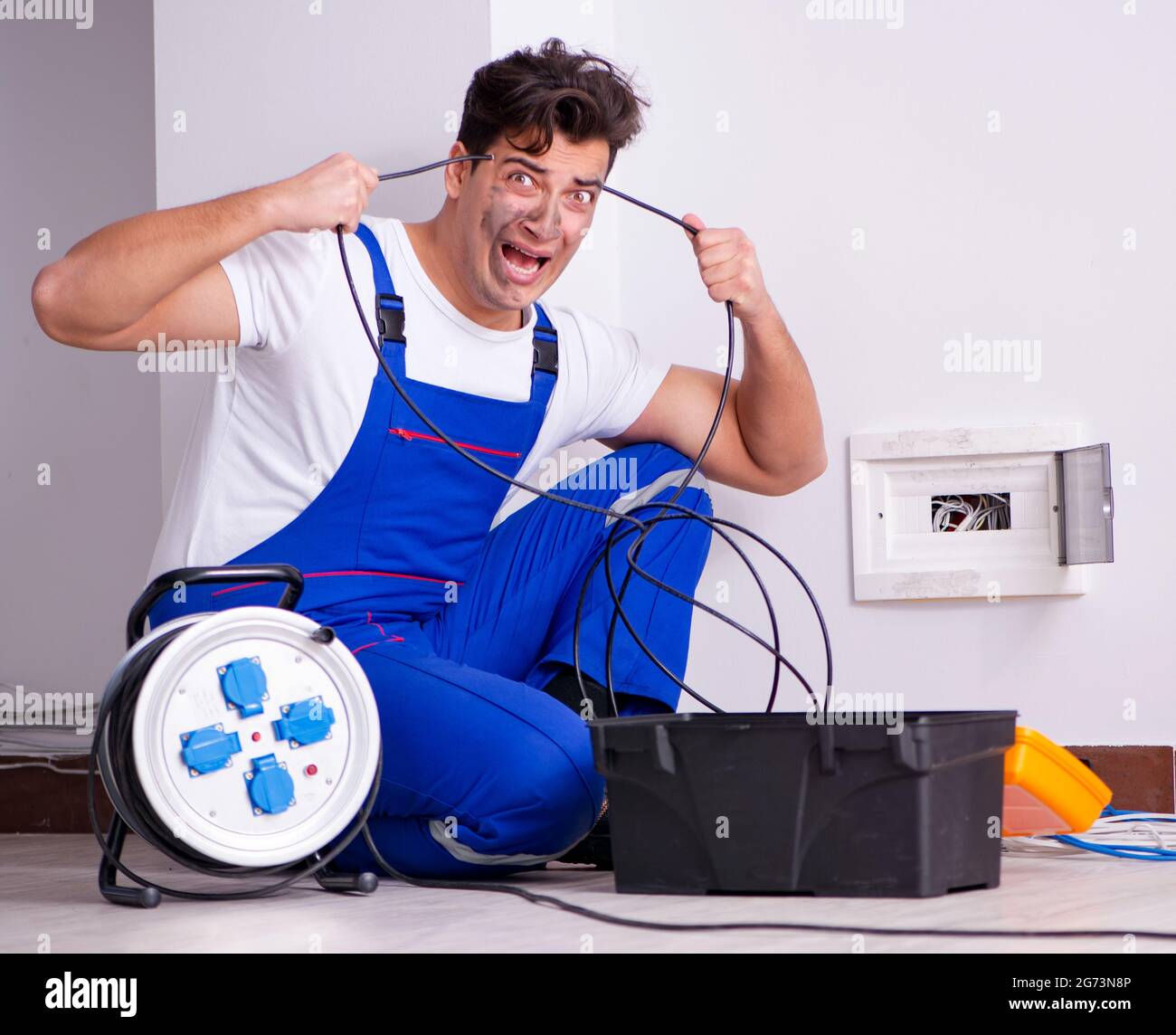 The funny man doing electrical repairs at home Stock Photo