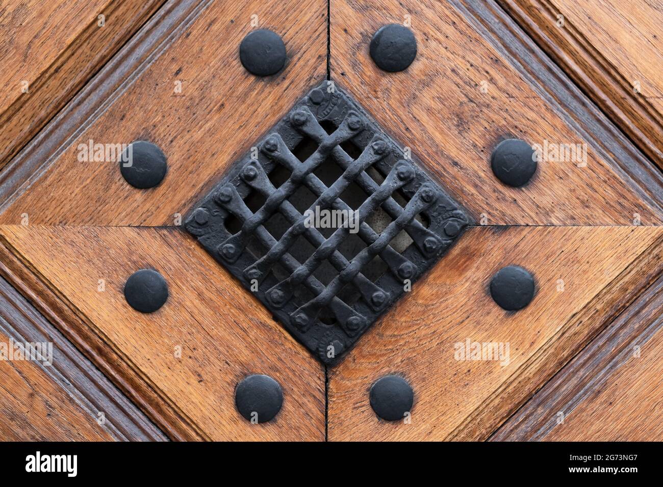 Detail of Old door. Iron Mesh on the wooden door with metallic rivets on it. Antique Decor Stock Photo