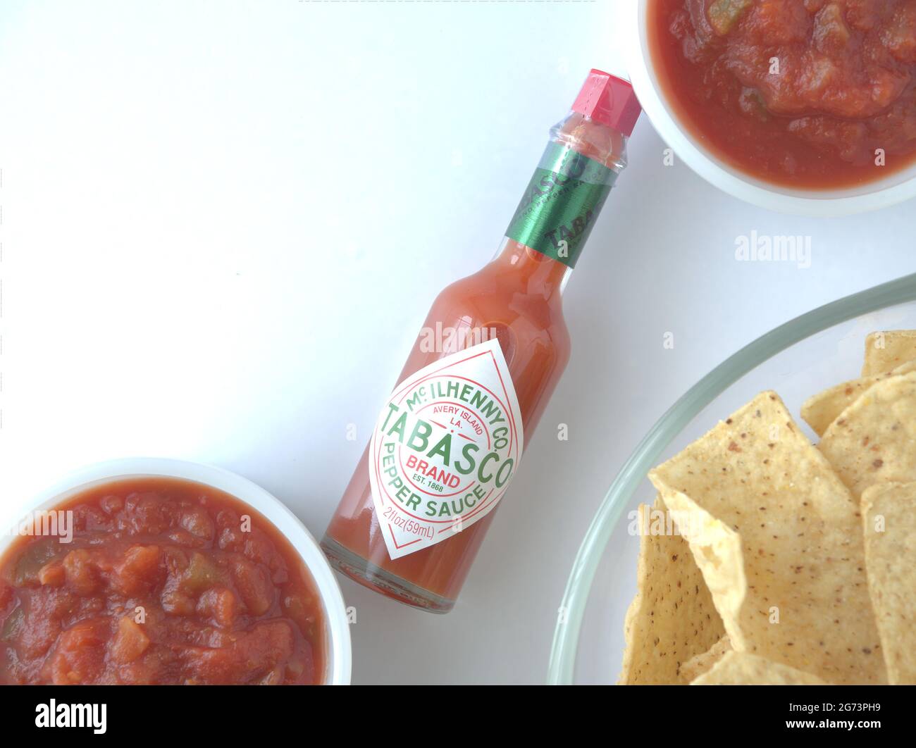 flat lay Red Tabasco Sauce bottle and two bowls of salsa and bowl of ...