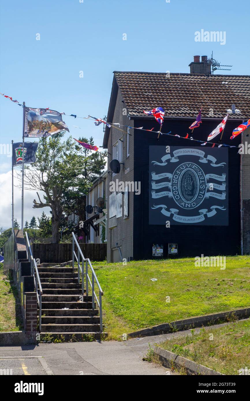 8 July 2021 Flags bunting and painted insignia adorn the local headquarters of the protestant UVF paramilitary association on Owebroe Drive in the Kil Stock Photo