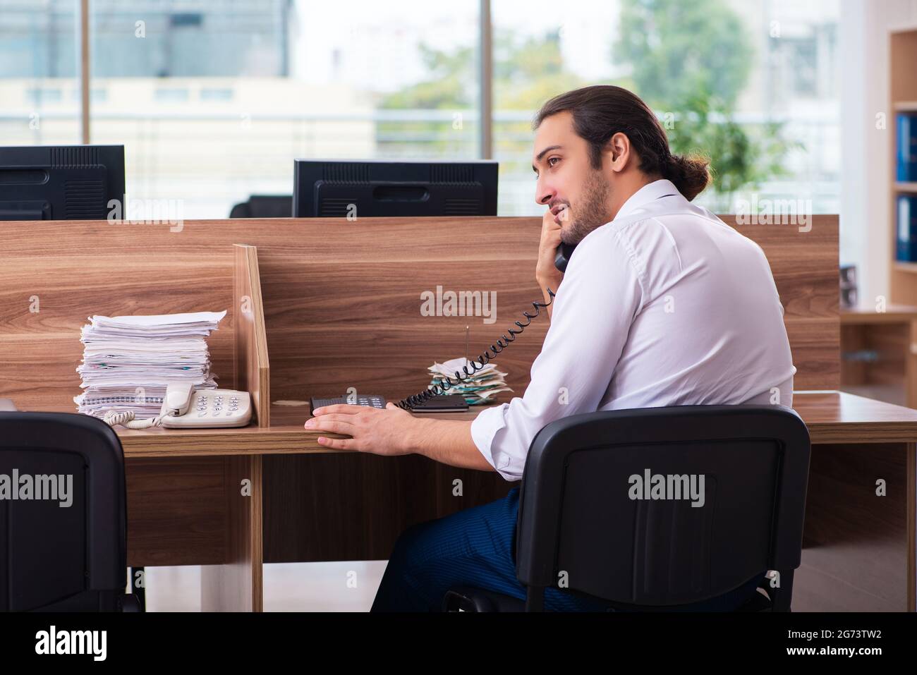 Young employee and too many work in the office Stock Photo - Alamy