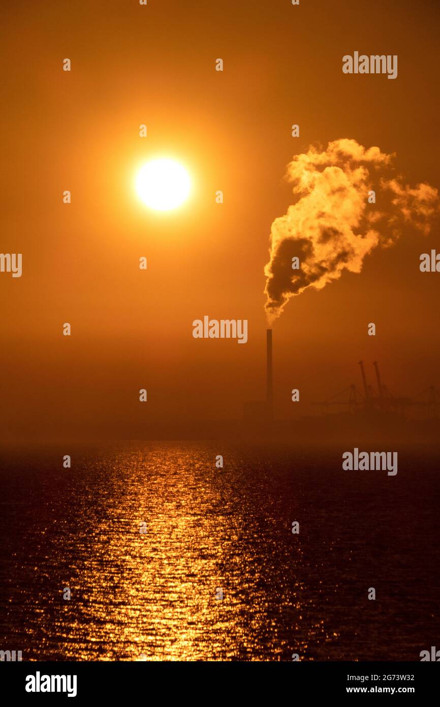 Sunset and Steam. The sunsets as steam rises from the chimney of a power station in Melbourne Australia . Stock Photo