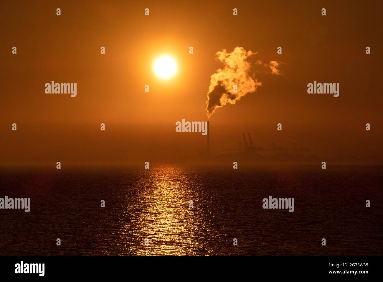 Sunset and Steam. The sunsets as steam rises from the chimney of a power station in Melbourne Australia . Stock Photo