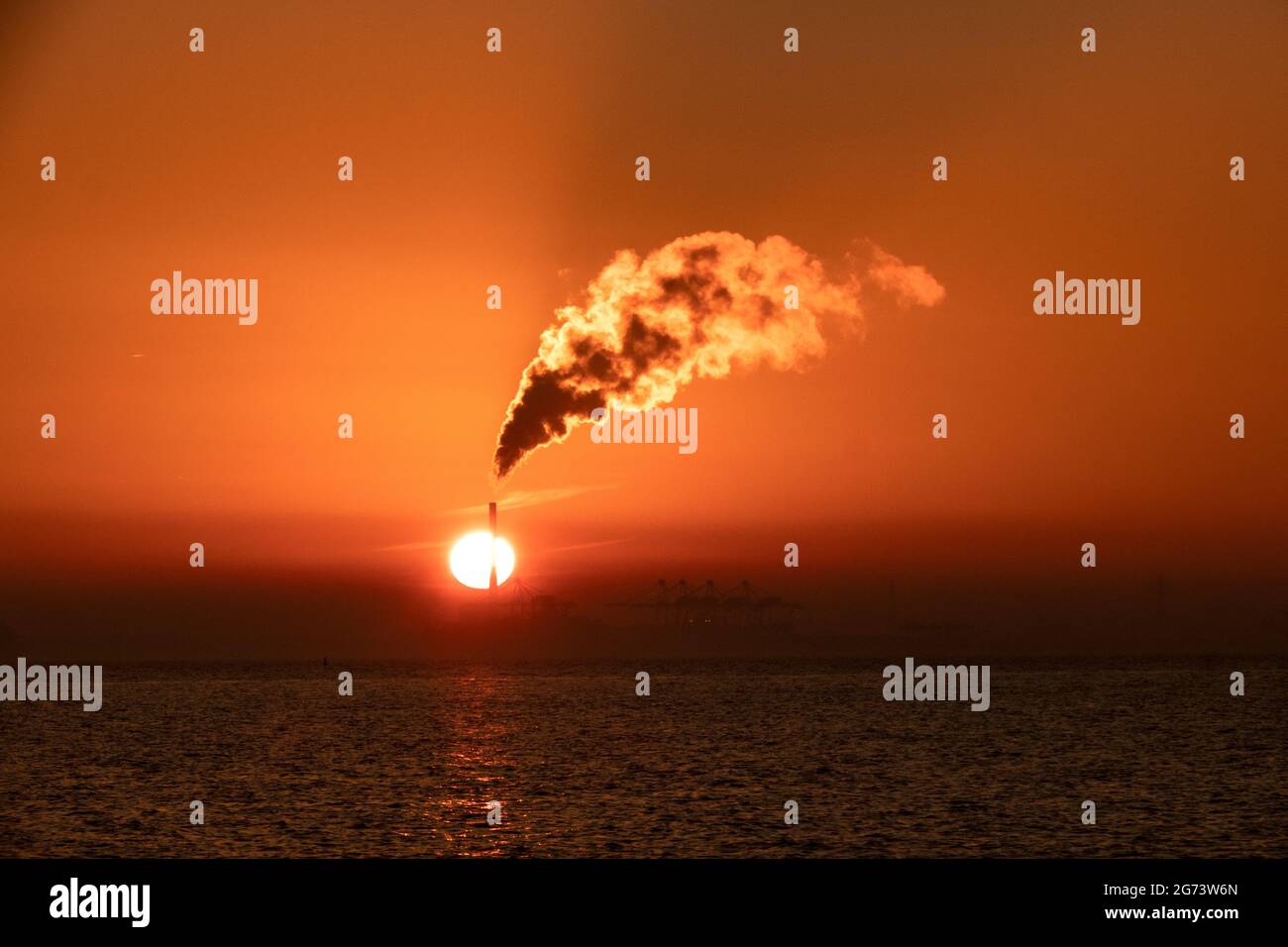 Sunset and Steam. The sunsets as steam rises from the chimney of a power station in Melbourne Australia . Stock Photo