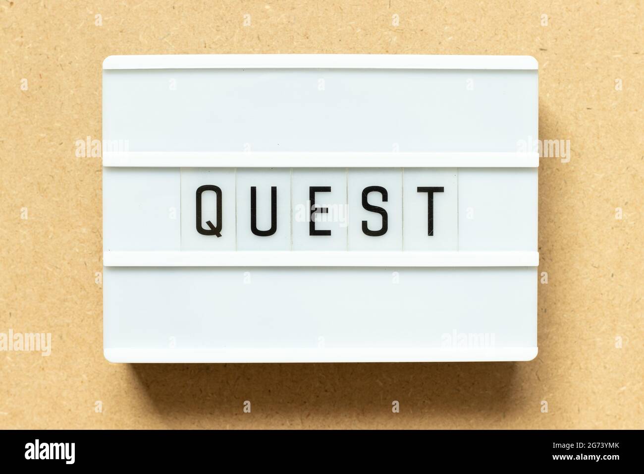 Lightbox with word quest on wood background Stock Photo