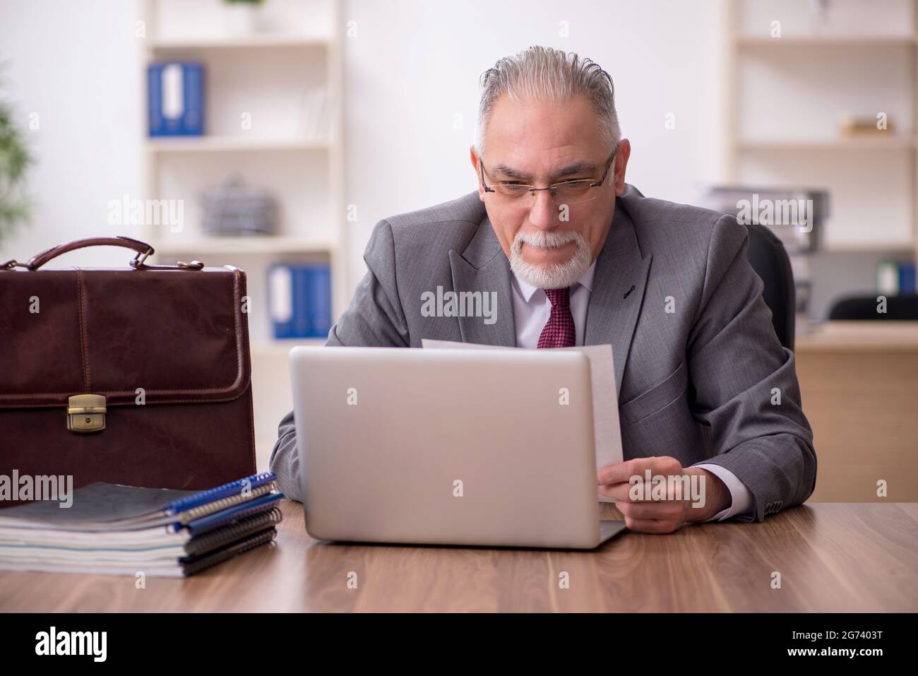 Old businessman employee working at workplace Stock Photo - Alamy