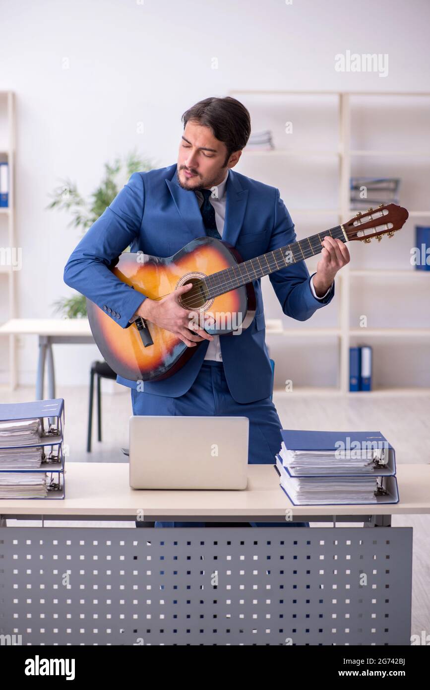 Young businessman employee playing guitar at workplace Stock Photo Alamy