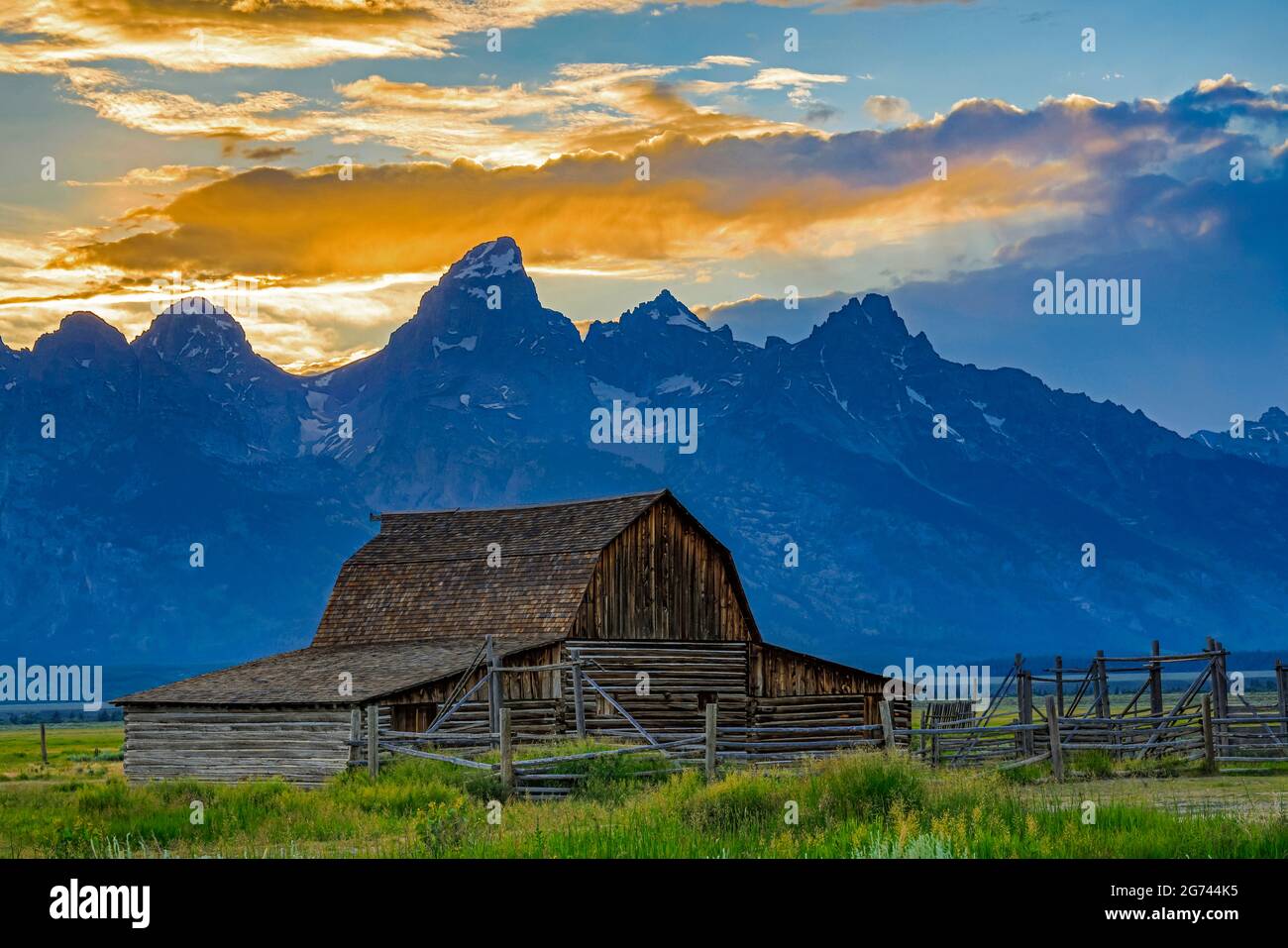 A view of the John and Bartha Moulton barn with the spectacular backdrop of the sunset over the Teton Range in Grand Teton National Park, WY, USA. Stock Photo