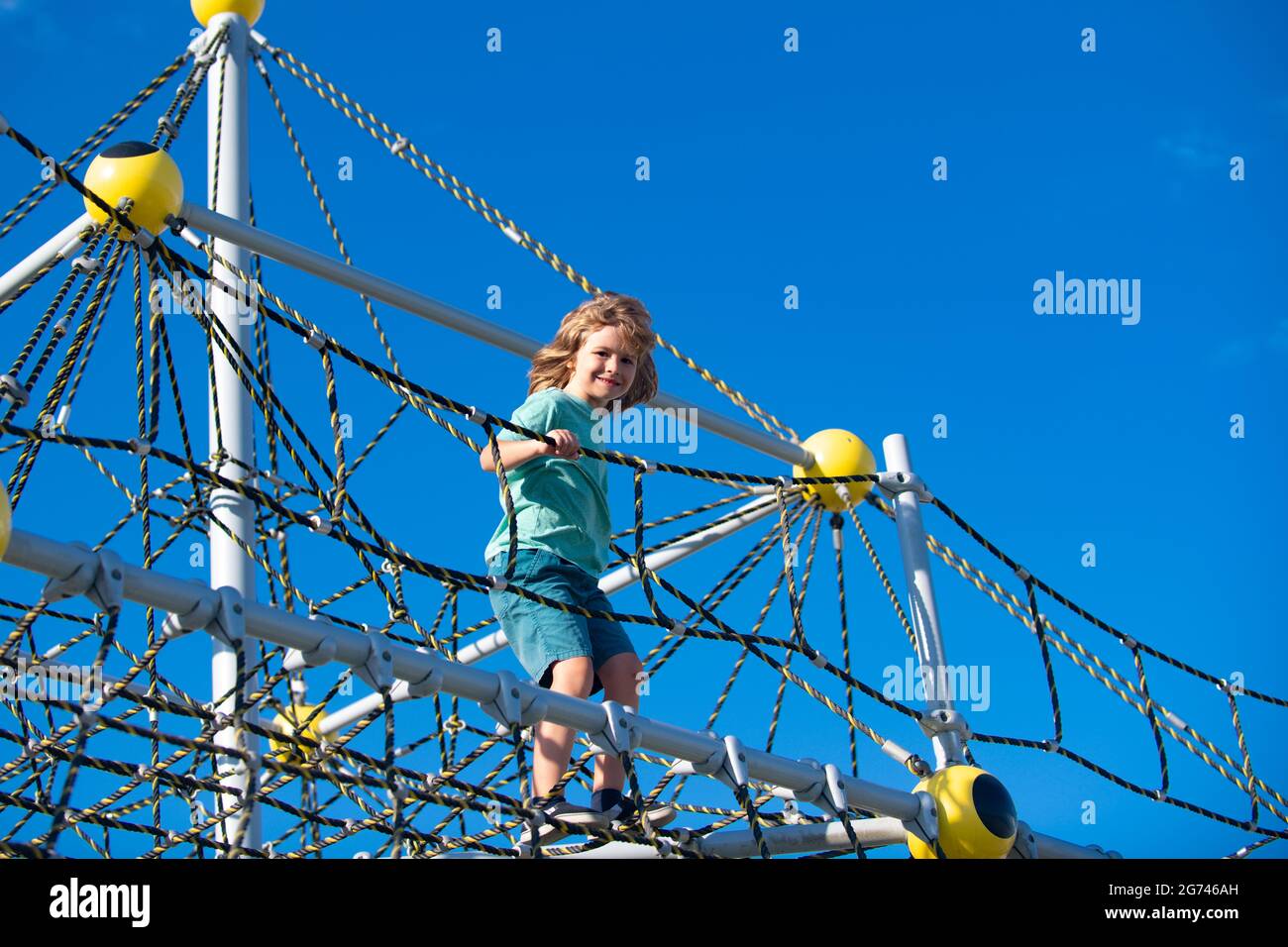 Kid boy playing on the rope outdoor playground Stock Photo - Alamy