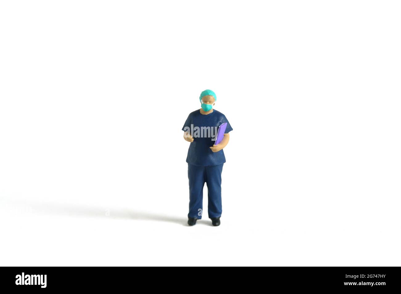 Miniature people toy figure photography. A women doctor wearing surgical gown with handing medical checkup document, isolated on white background. Ima Stock Photo