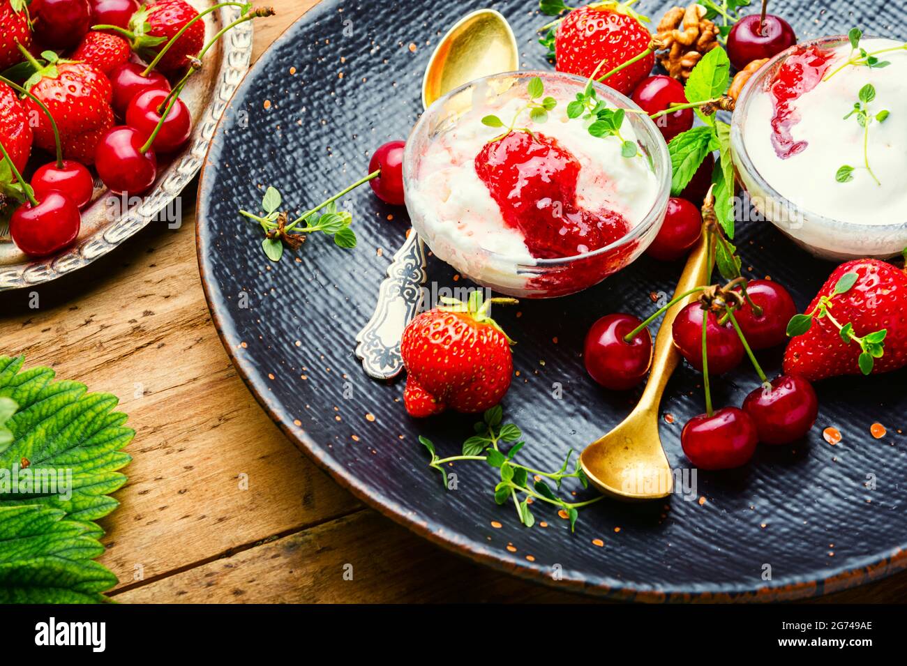 Summer dessert, ice cream with strawberries and cherries.Ice cream with berry jam on wooden table Stock Photo