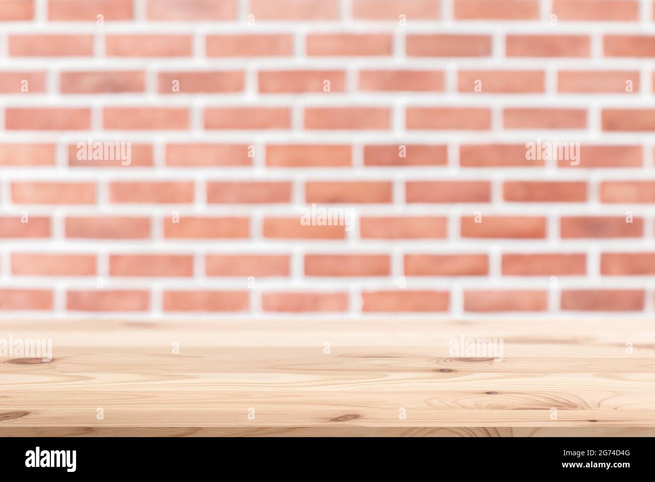 Retro brick wall with wooden table floor space for background advertising montage. Stock Photo