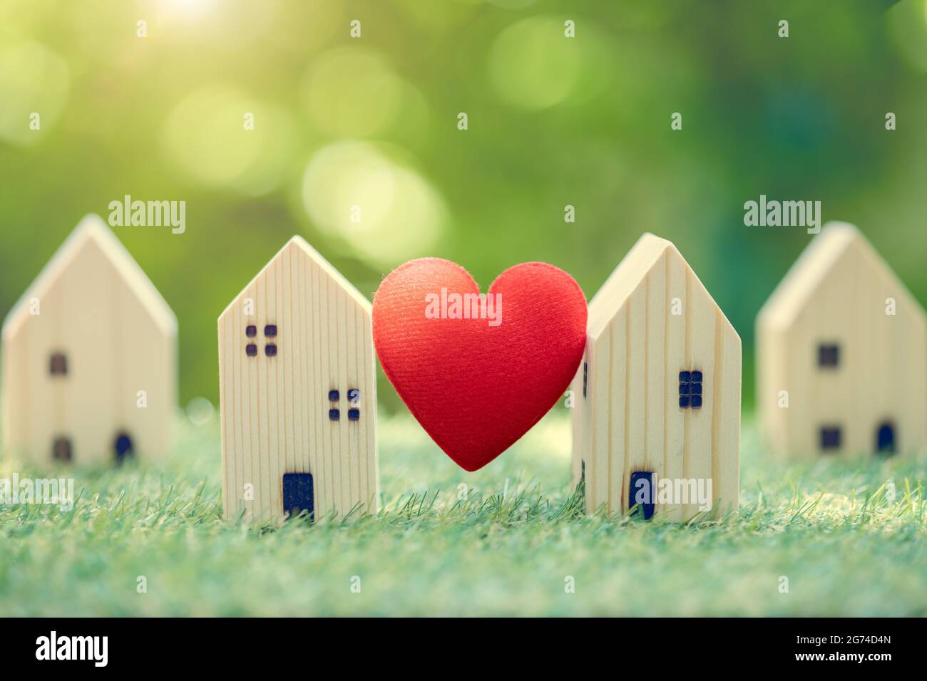 Love heart between two house wood model for stay at home for healthy community together on green fresh ecology natural environment. Stock Photo