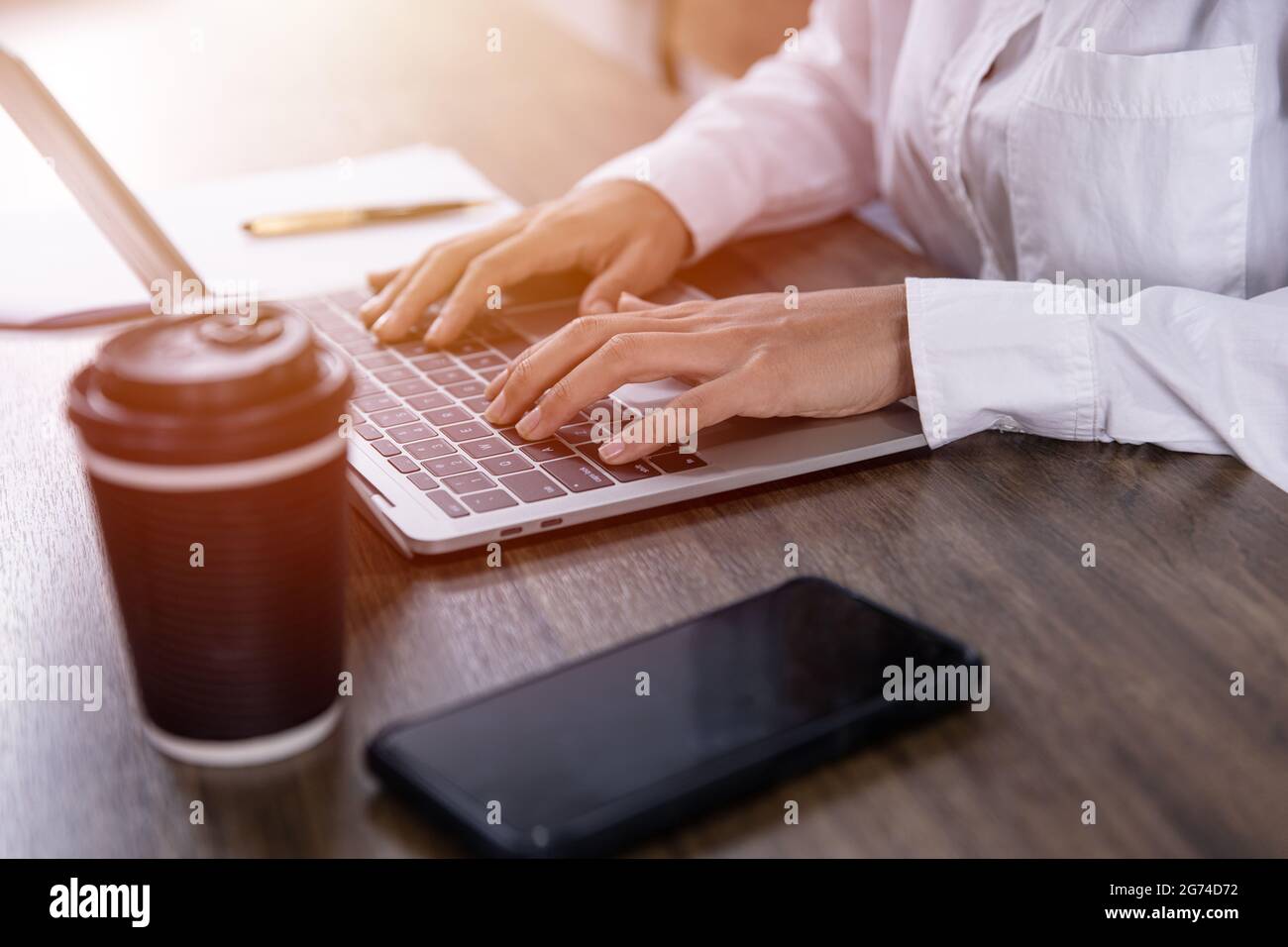 coffee cup  with indy girl freelance working in cafe with computer laptop on wooden table in the morning. Stock Photo