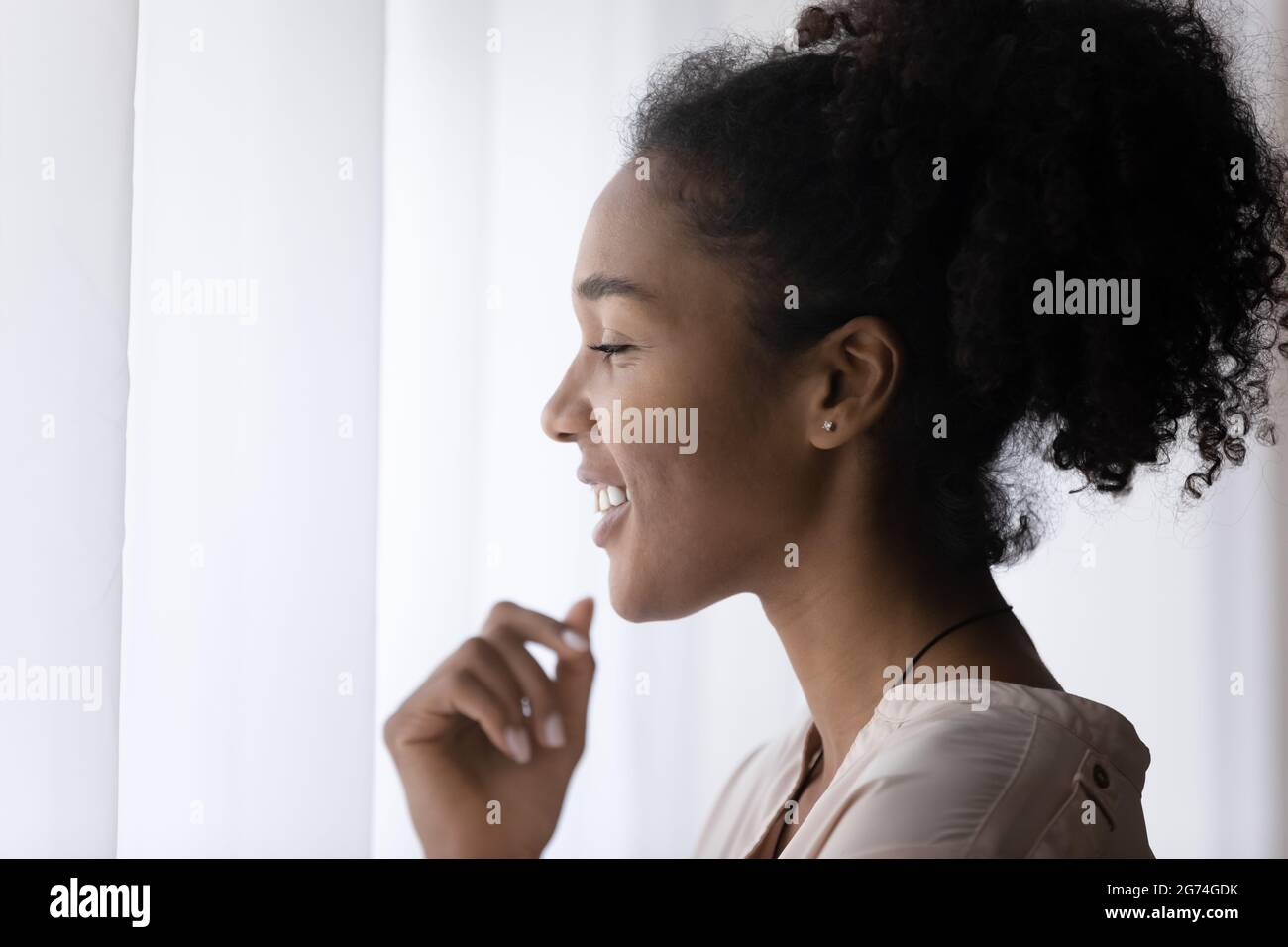Head shot profile of smiling dreamy African American woman Stock Photo