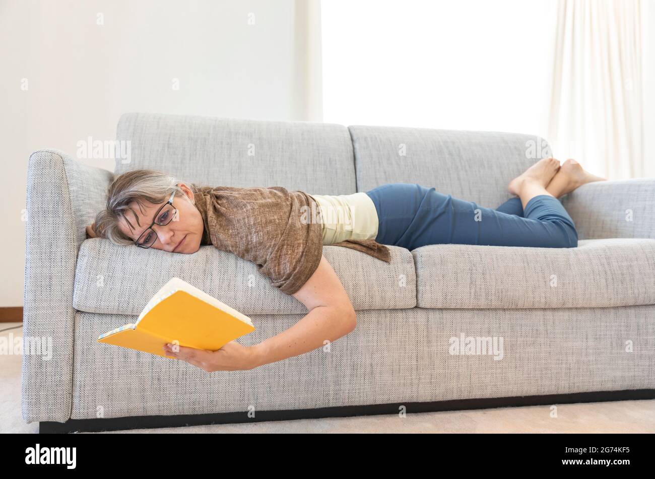 middle aged woman reading at home Stock Photo