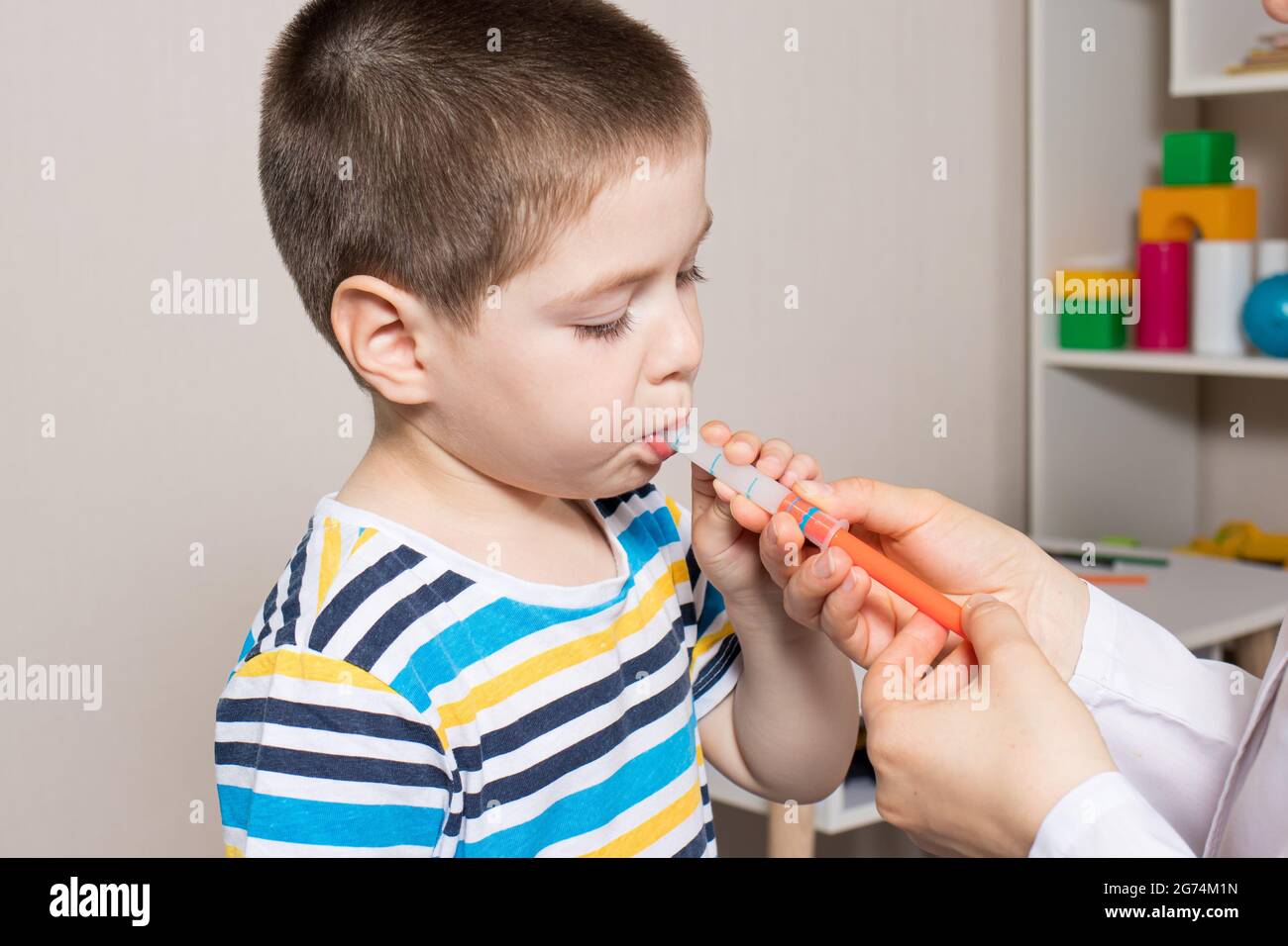 The pediatrician or nurse gives the child syrup in a measuring syringe