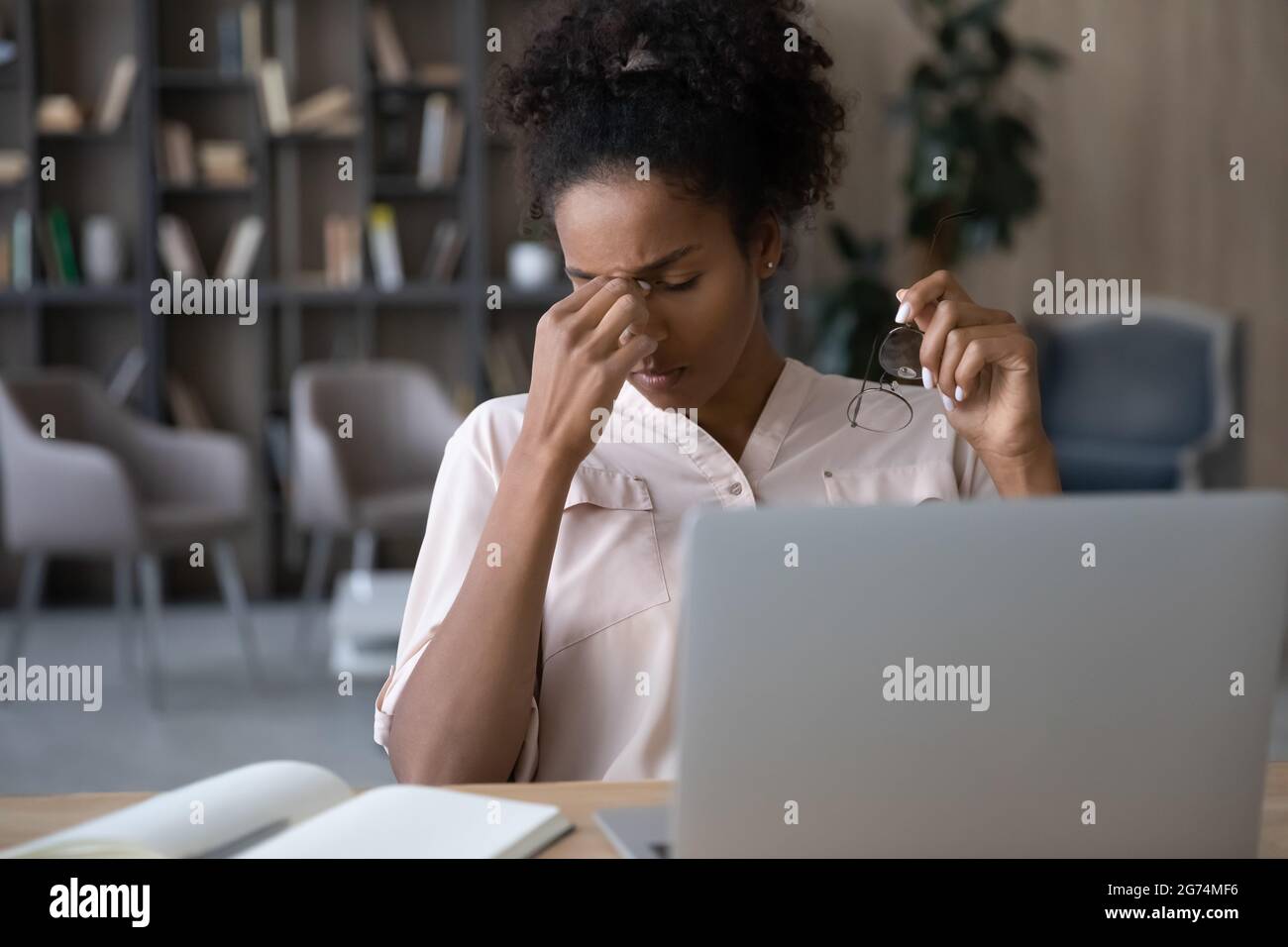 Exhausted African American woman taking off glasses, feeling eye strain