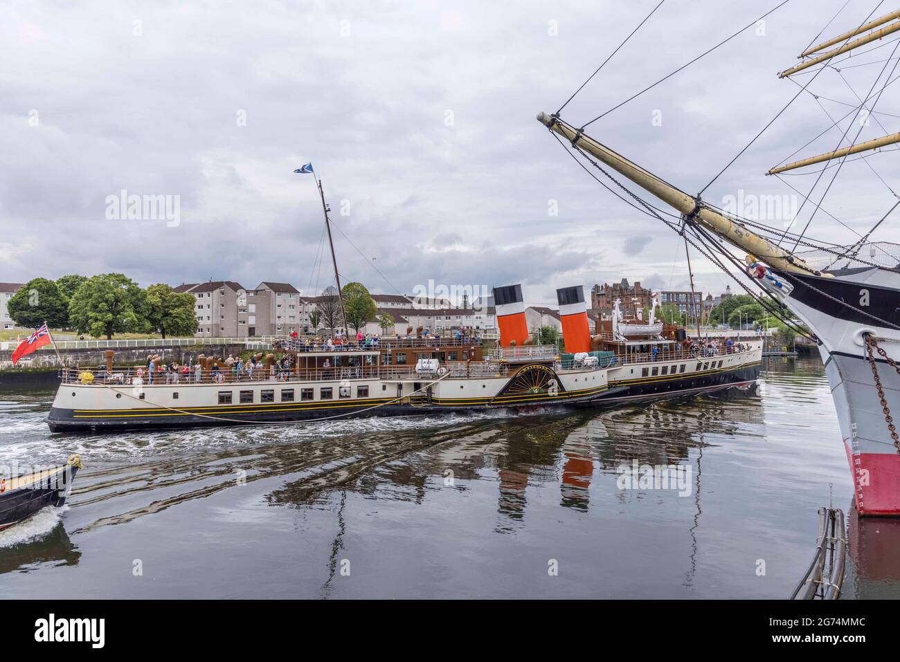 Glasgow, Scotland, UK. 11th July 2021. Pictured: The steamship Waverley passes the Tallship, Glenlee as it leaves Glasgow at the start of its daily trip around the Clyde estuary. Credit: Rich Dyson/Alamy Live News Stock Photo