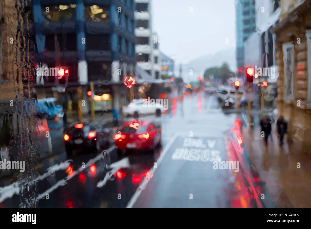 Cars at traffic lights on city street in heavy rain, Wellington, North