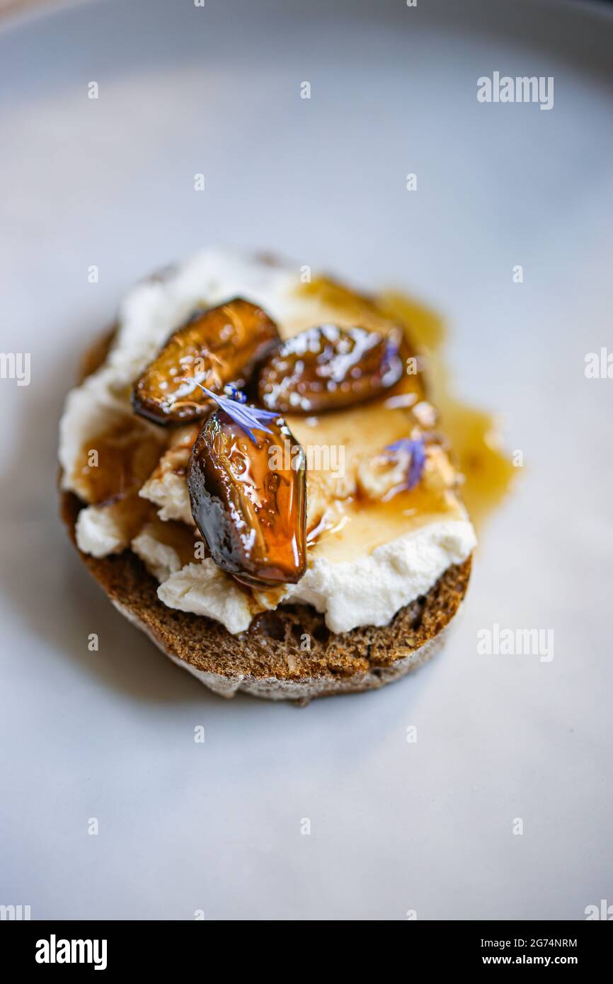 Delicious open toast with whipped ricotta topped with green walnuts jam Stock Photo