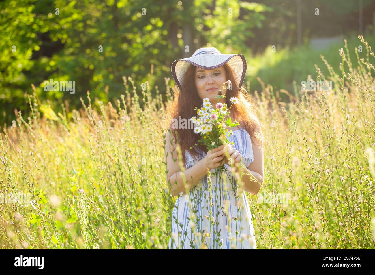 Woman walking in a field in summer sunny day Stock Photo - Alamy