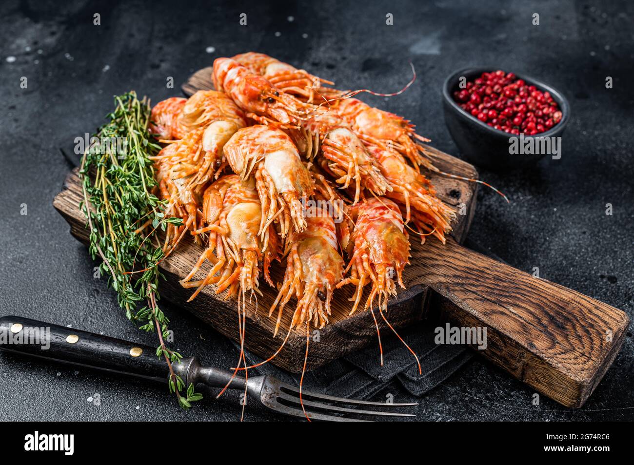 Cooked Greenland Prawn Shrimp on a wooden board. Black background. Top view Stock Photo