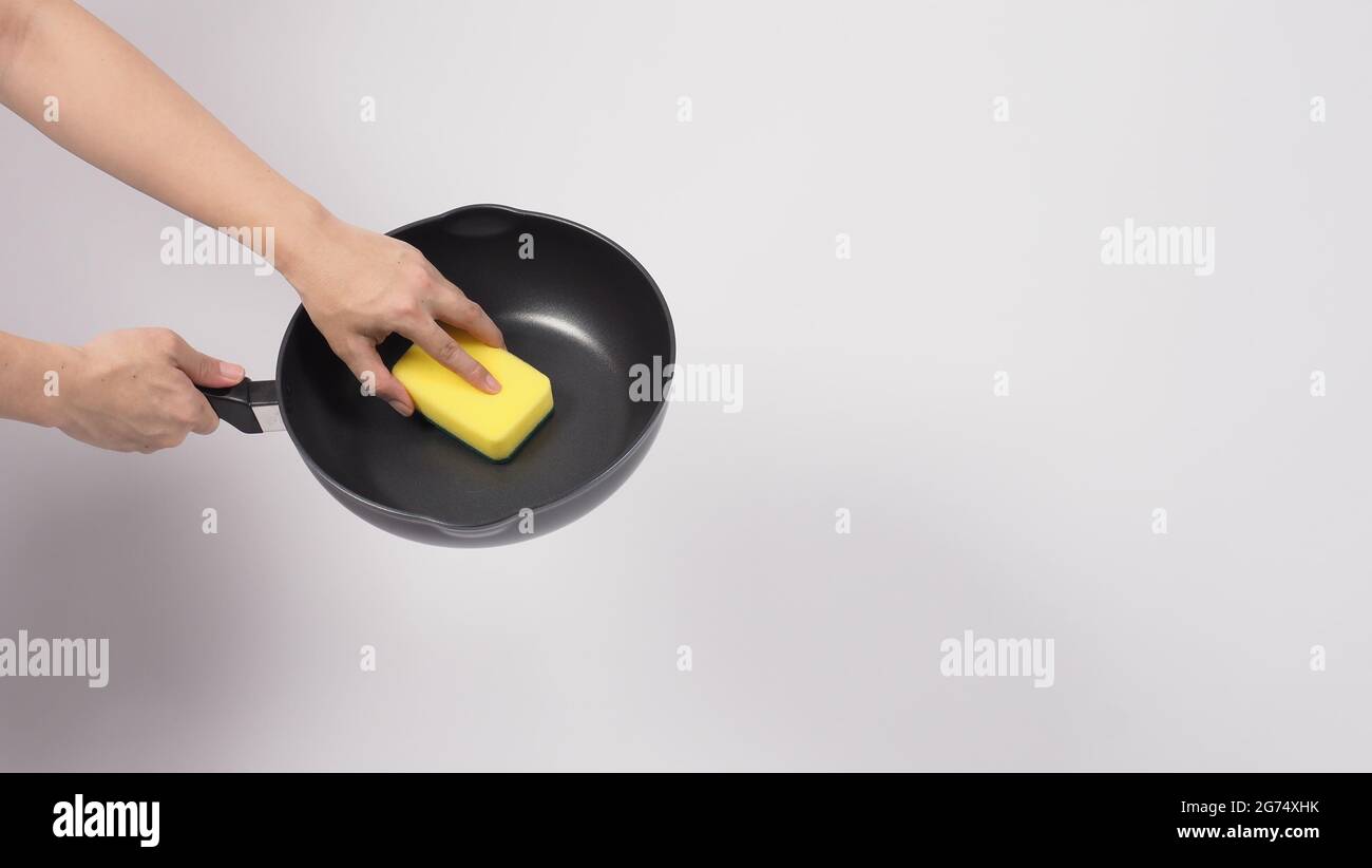 https://c8.alamy.com/comp/2G74XHK/pan-cleaning-man-hand-on-white-background-cleaning-the-non-stick-pan-with-handy-dish-washing-sponge-which-yellow-color-on-the-soft-side-and-green-on-2G74XHK.jpg