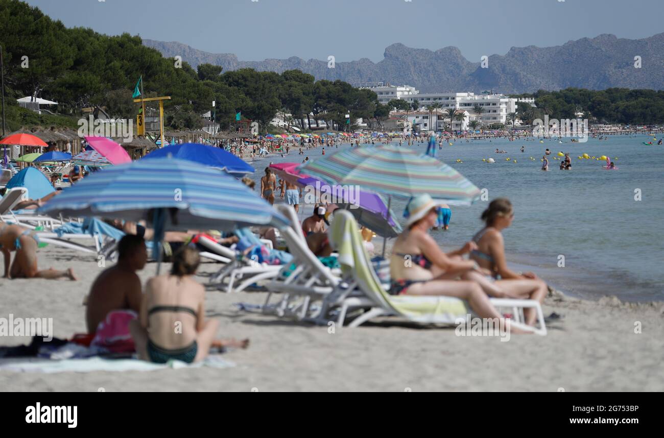 Maorca, Spain. 11th July, 2021. Many people enjoy the sun, sand and sea at the beach Playa de Muro in the north of Mallorca. The federal government has declared all of Spain with Mallorca and the Canary Islands in view of rapidly increasing Corona numbers to the risk area. The practical effects for Mallorca holidaymakers are limited for the time being. Credit: Clara Margais/dpa/Alamy Live News Stock Photo