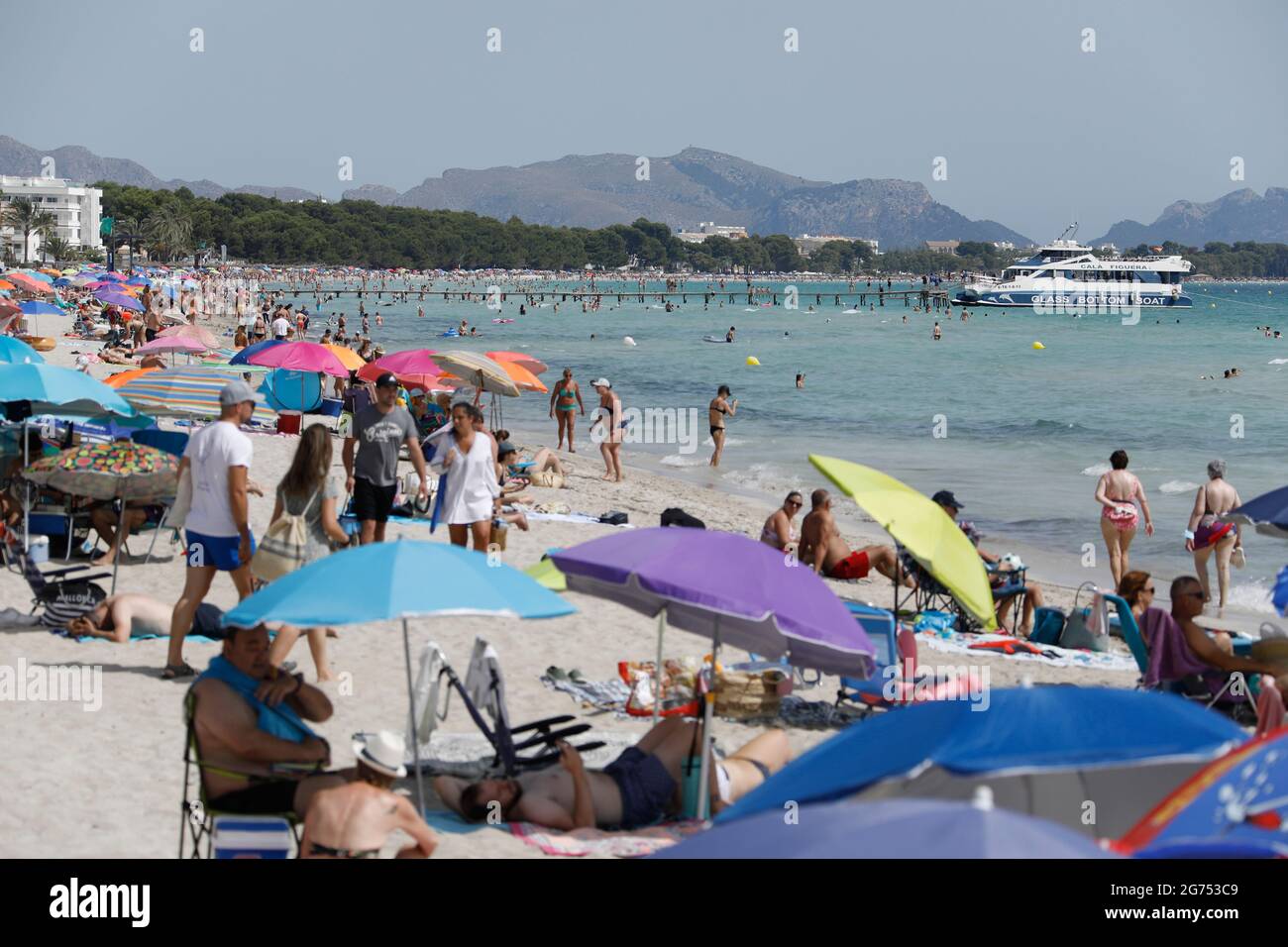 Maorca, Spain. 11th July, 2021. Many people enjoy the sun, sand and sea at the beach Playa de Muro in the north of Mallorca. The federal government has declared all of Spain with Mallorca and the Canary Islands in view of rapidly increasing Corona numbers to the risk area. The practical effects for Mallorca holidaymakers are limited for the time being. Credit: Clara Margais/dpa/Alamy Live News Stock Photo