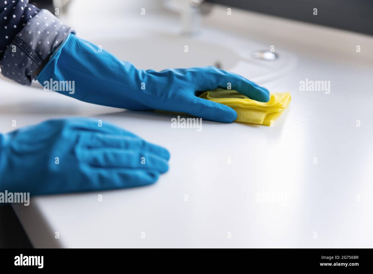 Housewife, cleaner, janitor wearing blue protective rubber gloves Stock Photo