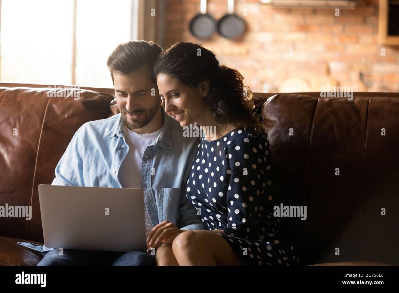 Happy couple sitting on couch at home together Stock Photo
