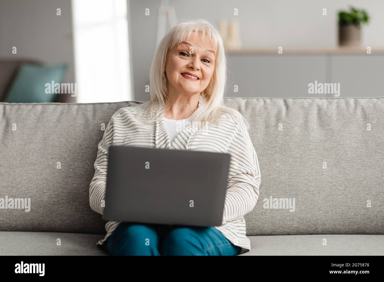 Mature woman sitting on couch hi-res stock photography and images - Alamy