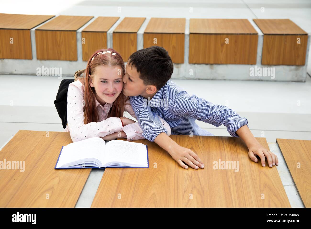 concept of first feelings, kiss, school love. boy kisses girl, teenager