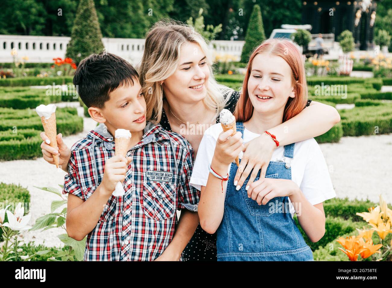 young woman teacher treats her students to teenagers ice cream, friendship concept Stock Photo