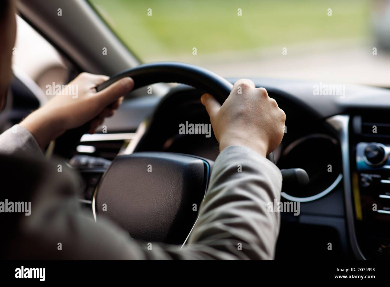 Sale and rental transport. Driver holding steering wheel sitting in new
