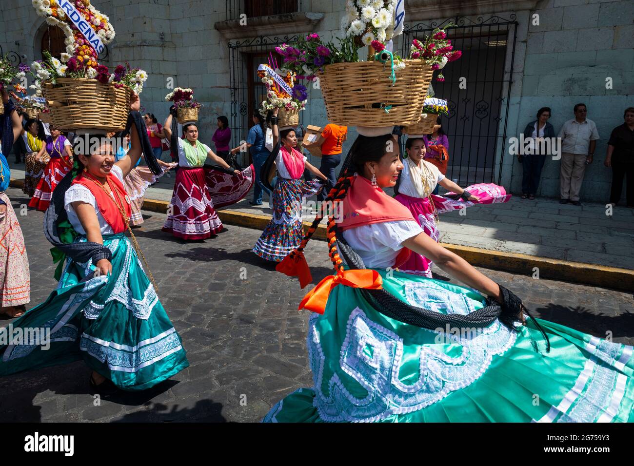 Oaxaca de Juarez, Mexico - May 15, 2014: A group of women wearing  traditional colorful dresses and carrying baskets with flowers, dancing in  a street Stock Photo - Alamy