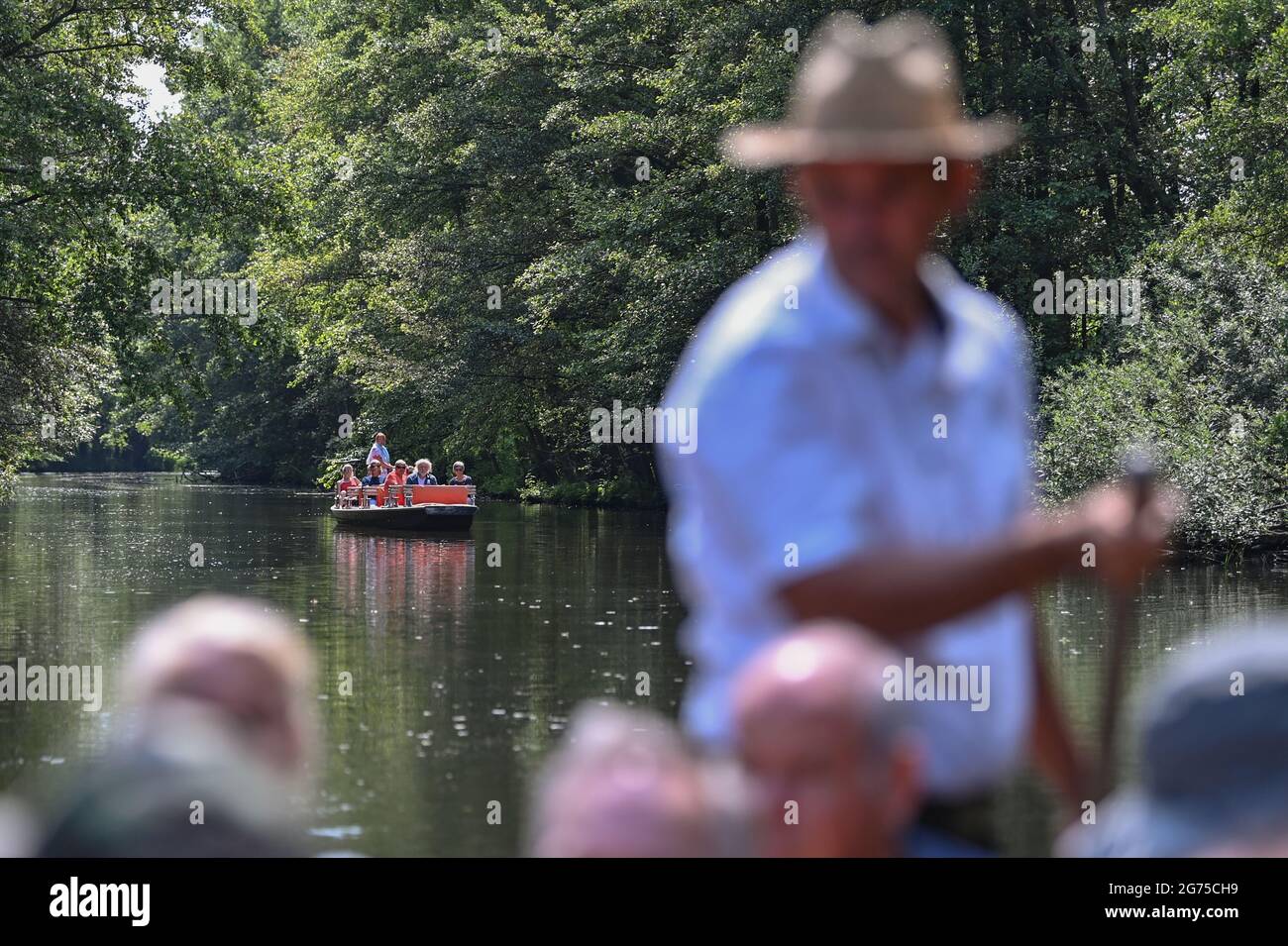 Schlepzig, Germany. 11th July, 2021. Excursionists take a boat trip in the Spreewald. Located around twelve kilometres north of Lübben, Schlepzig is considered the centre of the Lower Spreewald. The idyllic village is an ideal starting point for boat trips through the Spreewald. The village is over 1,000 years old, making it one of the oldest communities in the state of Brandenburg. Credit: Patrick Pleul/dpa-Zentralbild/dpa/Alamy Live News Stock Photo